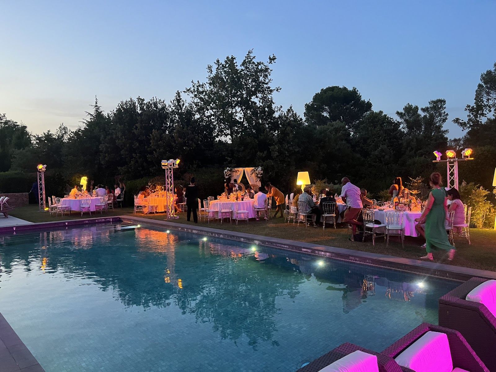 Réception de mariage au bord d'une piscine à l'heure dorée